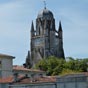 Le clocher de la cathdrale saint Pierre de Saintes. Ce clocher-porche domine le paysage urbain. Dominant les toits de la ville de prs de 58 mtres, il devait  l'origine supporter une flche en pierre qui l'aurait fait culminer  96 mtres. Demeur inachev  la suite des guerres de religion, il est couvert d'un dme en cuivre lui confrant une silhouette atypique. Un escalier  vis torte datant du xve sicle permet de rejoindre la plate forme sommitale.
