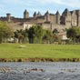 La ville de Carcassonne, en bordure de l'Aude, est connue pour sa fameuse Cit, ensemble architectural mdival restaur par Viollet-le-Duc au XIXe sicle. et inscrit au patrimoine mondial de l'UNESCO depuis 1997. L'histoire de Carcassonne est directement lie  celle de la cit. C'est en 1247 que la ville s'tend rellement hors de la cit. Il s'agit de la ville basse ou bastide Saint-Louis. Au sud de la cit, cinq chteaux forts (chteau de Termes, chteau d'Aguilar, chteau de Quribus, chteau de Peyrepertuse et chteau de Puilaurens), dsigns comme les  cinq fils de Carcassonne , dont les ruines subsistent encore, dfendaient le passage du Languedoc contre les Espagnols. La ville de Carcassonne entretient la lgende selon laquelle le nom de la ville de Carcassonne daterait du dbut du IXe sicle. Au moment des faits, la ville aurait t sarrasine. Charlemagne aurait fait le sige, mais la matresse des lieux, dame Carcas, aurait fort rsist. Les deux armes seraient devenues affames. Tandis qu'il n'aurait rest qu'une mesure de bl et un petit cochon dans la cit, la dame Carcas aurait eu l'ide de dmoraliser ses adversaires. Le porcelet aurait t engraiss, puis projet par dessus les remparts. Pensant que la ville avait encore beaucoup de nourriture, Charlemagne aurait fait lever le sige.  ce moment, dame Carcas aurait fait sonner les trompettes et, Charlemagne revenant sur ses pas, la dame Carcas lui aurait propos la paix. D'o l'expression  Carcas sonne .