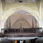 La premi�re trav�e, � l'entr�e est coup�e � mi-hauteur par une tribune en bois de ch�taignier dont le poids est report� sur deux poutres des chapelles lat�rales pour ne pas r�tr�cir la vue. On y acc�de par un escalier au fond de la nef.