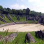  Tmoignage de l'poque romaine, l'amphithtre est achev au dbut du rgne de l'empereur Claude. Mesurant 126 mtres sur 102, il est reconnaissable  sa structure particulire, la cavea tant appuye sur deux versants du  Vallon des Arnes  et sur un remblai. Animaux sauvages et gladiateurs accdaient  l'arne par deux vomitoria tablis  l'ouest et  l'est.