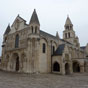 Poitiers : Eglise Notre Dame La Grande. L'glise est mentionne ds le Xe sicle sous le vocable de Sancta Maria Major rfrence  l'glise romaine du mme vocable, Sainte-Marie-Majeure. Possdant un double statut, collgiale et paroissiale, elle fait partie du domaine de l'vque de Poitiers. Sa position jouxte le Palais des Comtes de Poitou-Ducs d'Aquitaine (actuel palais de justice de Poitiers), n'est certainement pas innocente du point de vue politique, les vques de Poitiers tant barons du Poitou. L'ensemble de l'difice est reconstruit dans la seconde moiti du XIe sicle, en pleine priode romane, et consacr en 1086 par le futur pape Urbain II.  Le clocher date du XIe sicle. Il tait  l'origine beaucoup plus marqu : le premier niveau est aujourd'hui dissimul par les toitures. Situ  l'emplacement de la croise, il prsente une base carre puis un niveau circulaire surmont d'un toit en cailles. (Photo Dominique Trioire)