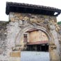 D�tail du portail de la Osa: une ourse enserre un enfant. Les seigneurs de Doriga avaient un fils. Un jour, alors que la nourrice le promenait dans un bois proche de Narcea, une ourse sortit du bois, saisit la robe de l'enfant entre ses dents et l'emporta.Aux cris de la nourrice,les serviteurs du palais sortirent et firent une battue � travers le bois. Lorsqu'ils trouv�rent l'enfant, celui-ci t�tait l'ourse qui le l�chait on ne peut plus maternellement. Apr�s avoir effray� l'ourse, ils purent r�cup�rer l'enfant.C'est cette sc�ne qui est repr�sent�e sur ce vieux portail du monast�re et qui serait � l'origine du dit monast�re, car les parents reconnaissants l'auraient fait �riger.