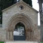 Ce portail roman qui donne accs au cimetire provient des ruines de l'ancien hpital de Saint Jean  d'Acre. Il a t transport et reconstruit par les mains expertes et pieuses d'un simple maon. D'influence mozarabe, il prsente  cinq voussures sur colonnettes, dont deux denticules, au-dessus des quelles se trouve un oculus orn d'une rosace en arabesques. Le tout est surmont d'une croix sur un chapiteau reprsentant l'habituel combat de chevaliers. Ceux qui se trouvent sur les colonnettes voquent des scnes de la vie quotidienne des plerins.