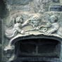 Au-dessus de la vasque en marbre, deux anges tiennent un personnage encord.