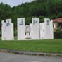 Sculpture Archtype Agora d'Amnesty International. A Montgut-Plantaurel, douze dalles de bton tournent autour d'une sphre de granit brise. sur les faces extrieures, on a reprsent des pictogrammes qui retracent l'histoire de l'criture depuis les signes relevs sur les grottes prhistoriques jusqu' l'criture informatique. Sur les faces intrieures sont fixes des plaques rouges qui portent le prnom d'un prisonnier d'opinion, la date et le pays d'emprisonnement; quand un dtenu est libr, sa plaque est retire et une nouvelle identit vient (hlas...) prendre sa place.