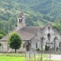 Eglise Saint Martin  Luzenac. C'est au XVIIIe sicle que la faade baroque a t ajoute au portail d'origine romane en lui donnant cette extraordinaire allure  hispanisante. Cette glise cultive l'originalit : dj le clocher (voir photo suivante) n'est pas ordinaire avec ses douze pans , ses deux tages de baies et surtout le cne de pierre qui le coiffe bizarrement  l'image des ruches de la rgion. Au XVe sicle, la population ayant considrablement augment, on dcida d'agrandir l'glise en ajoutant de part et d'autre du btiment  deux bas-cts dots de leurs portes respectives. Il reste de beaux vestiges romans dans l'abside orne de modillons trs simples et dans les chapiteaux du portail sculpts de feuillages et de superbes visages.